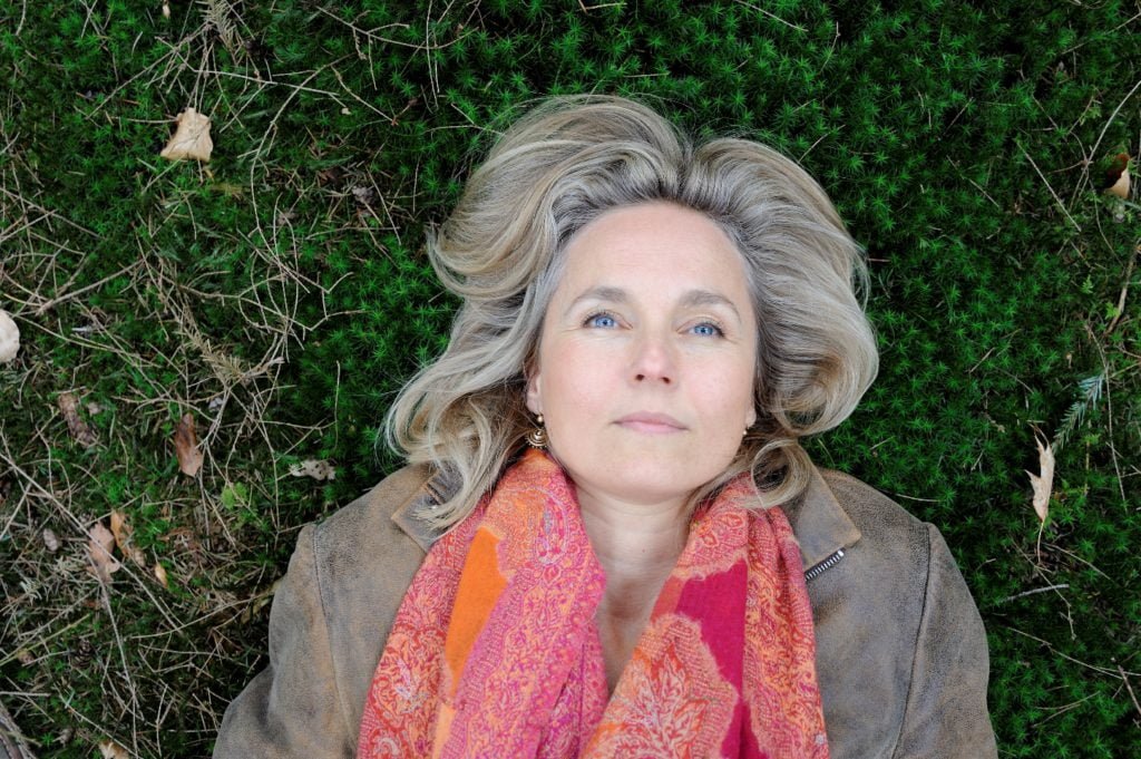 Chantal van den Brink ligt op mos