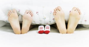voeten van aanstaande ouders en schoenen van ongeboren baby