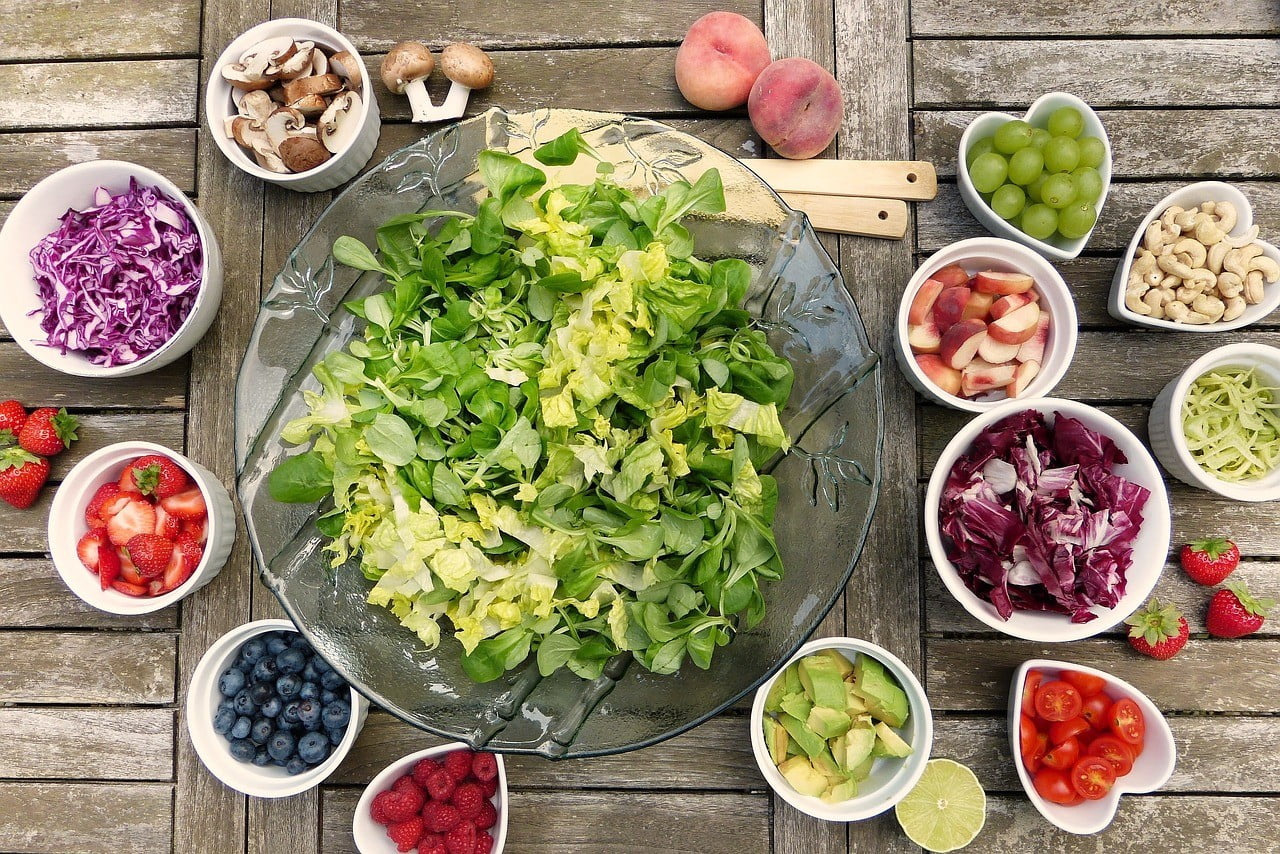 Verschillende schaaltjes met groenten, fruit, noten en ander eten.