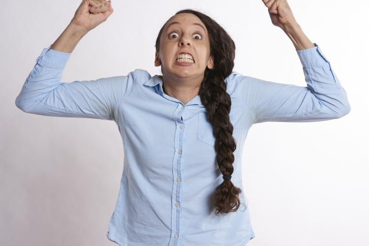 vrouw doet armen omhoog en stelt zich aan