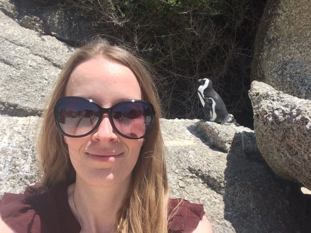 Femke de Grijs staat voor een pinguïn in Zuid-Afrika