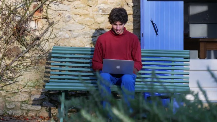 Mathijs van der Beek zit op een bankje in de Dordogne