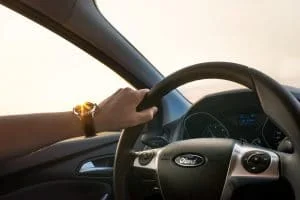 een hand die een stuur van het merk Ford vasthoudt
