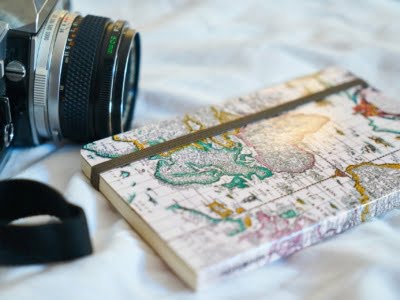 camera met notitieboek met wereldkaart