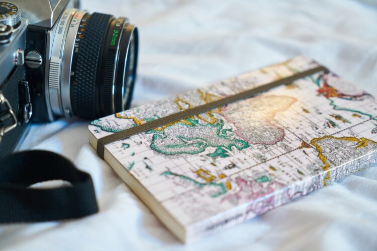 camera met notitieboek met wereldkaart