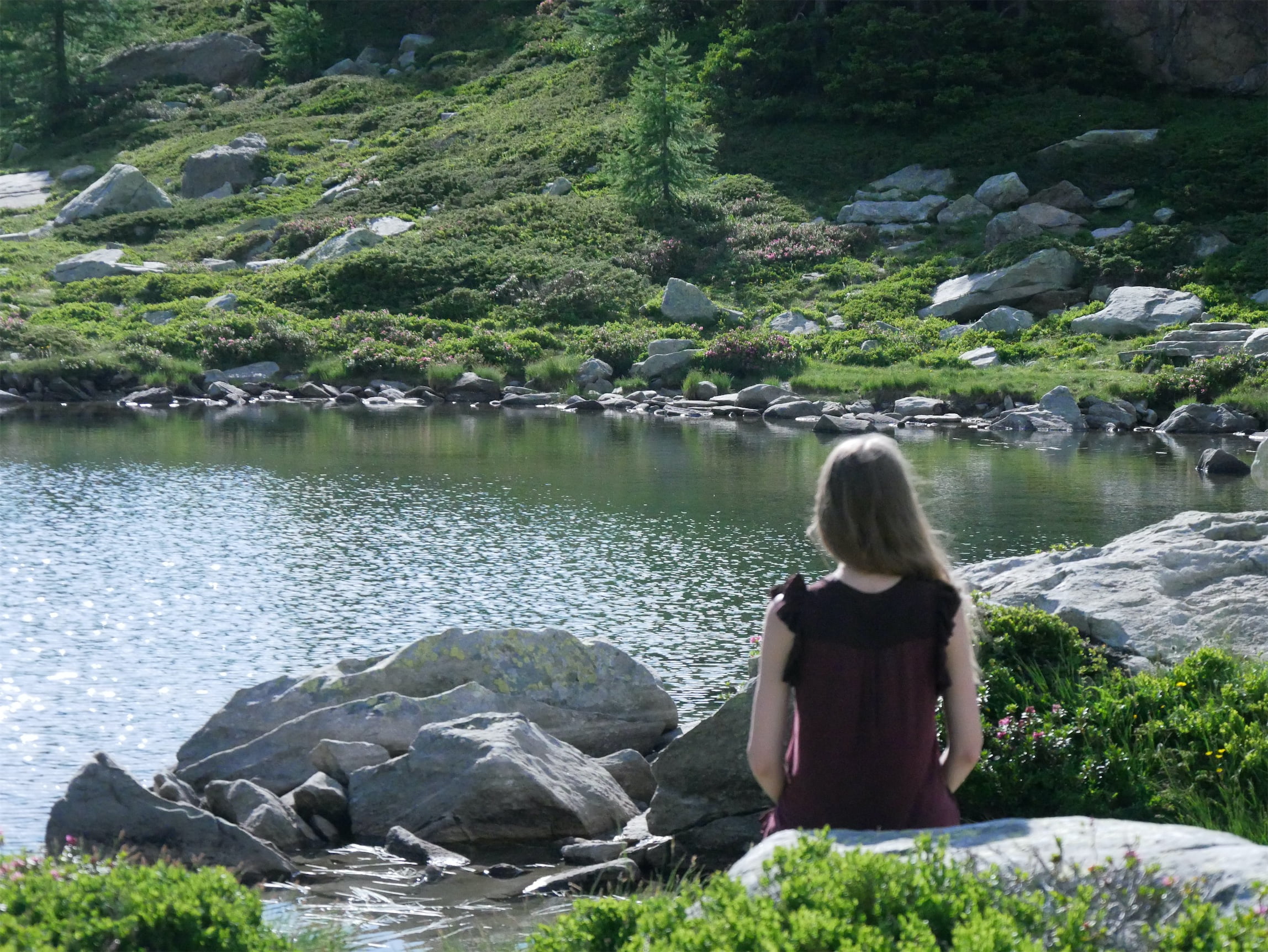 Femke sits by a lake in Switzerland
