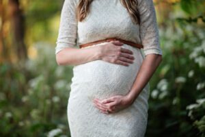 zwangere vrouw in witte jurk
